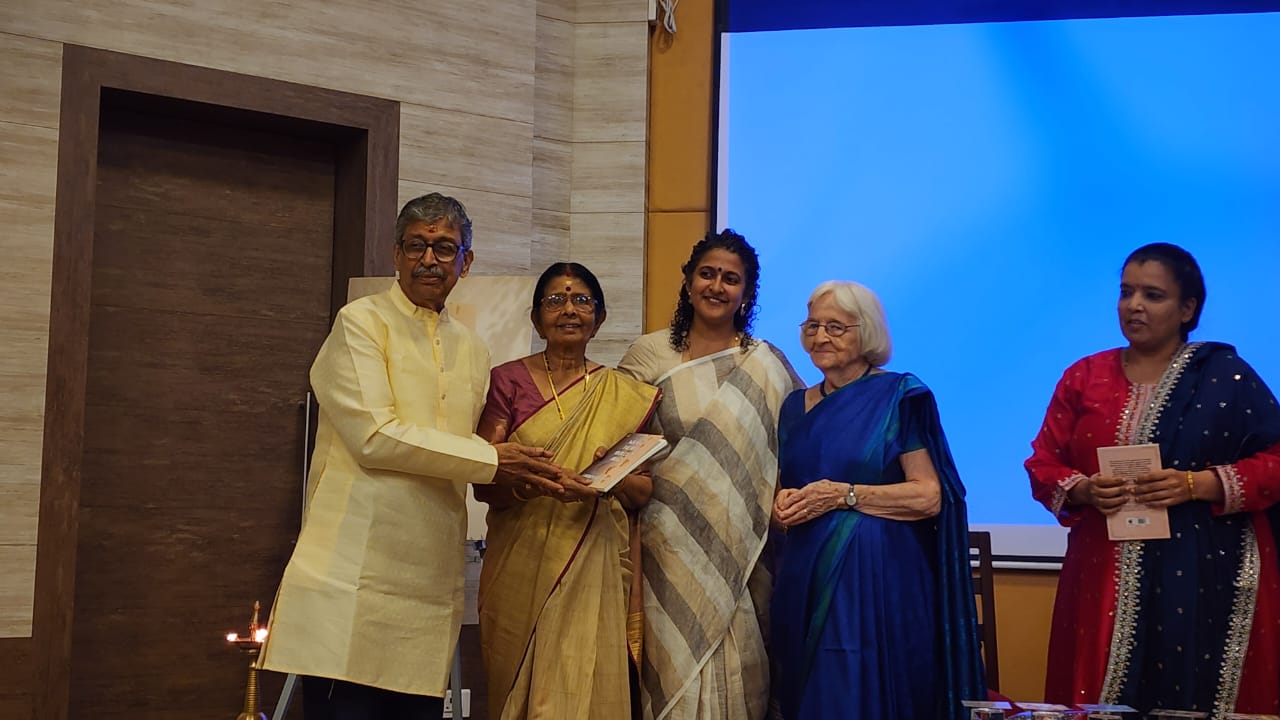 Guests on stage holding copies of the book