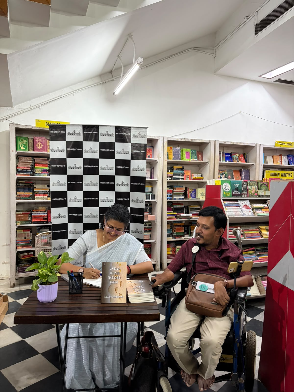 Lakshmi Sudhakaran signing a book for a reader